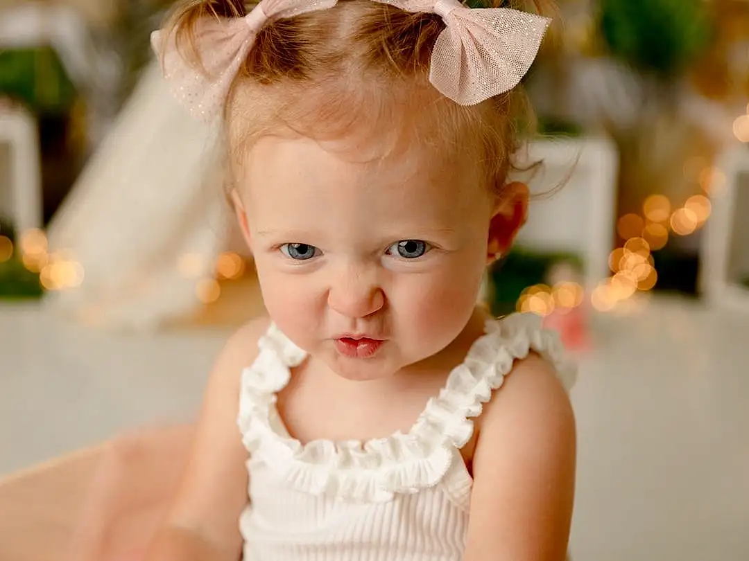 Dress, Flash Photography, Happy, Iris, Toddler, Eyelash, Baby & Toddler Clothing, Baby, Child, Event, Headpiece, Fashion Accessory, Jewellery, Hair Accessory, Portrait Photography, Fun, Bridal Accessory, Ceremony, Sitting, Wedding Ceremony Supply, Person