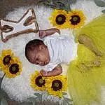 Flower, Toy, Petal, Textile, Happy, Yellow, Plant, Baby & Toddler Clothing, Baby, Headgear, Toddler, Stuffed Toy, Linens, Cut Flowers, Bed, Event, Baby Products, Baby Sleeping, Flowering Plant, Person