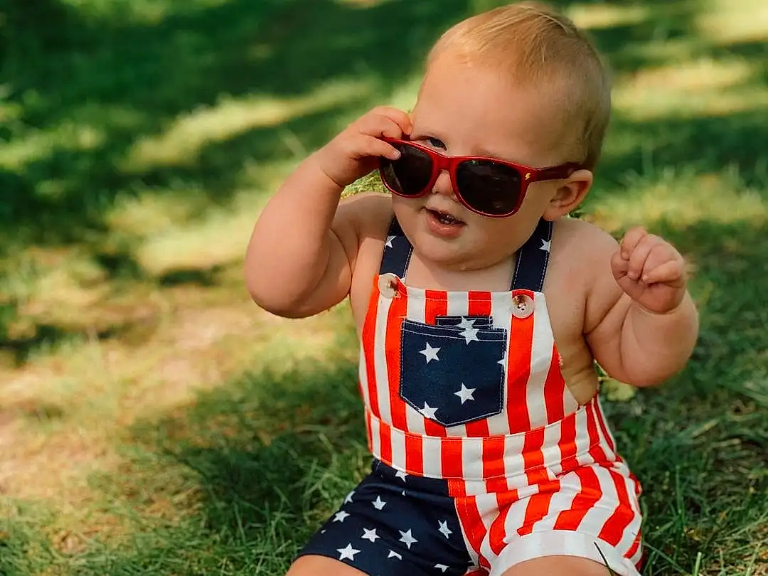 Glasses, Goggles, Vision Care, Sunglasses, Leg, People In Nature, Baby & Toddler Clothing, Happy, Shorts, Grass, Sunlight, Eyewear, Toddler, Child, Leisure, Summer, Personal Protective Equipment, Thigh, Recreation, Meadow, Person