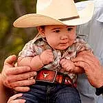 Hand, Eyes, Hat, Sun Hat, Plant, Headgear, Finger, Toddler, Happy, Child, Grass, Thumb, Event, Fun, Sitting, Fashion Accessory, Pattern, Cowboy Hat, Baby, Belt, Person, Headwear