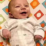 Clothing, Face, Nose, Cheek, Skin, Head, Outerwear, Photograph, Smile, Facial Expression, White, Baby & Toddler Clothing, Sleeve, Baby, Orange, Comfort, Happy, Toddler, Linens, Collar, Person