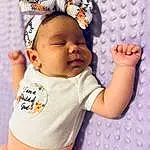 Clothing, Cheek, Skin, Lip, Chin, Hairstyle, Arm, Facial Expression, Baby & Toddler Clothing, Human Body, Textile, Baby, Sleeve, Cap, Eyelash, Happy, Gesture, Iris, Finger, Person