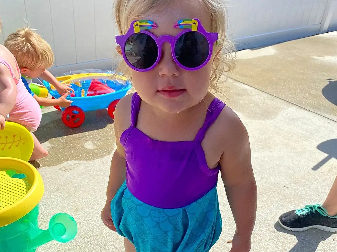 Glasses, Hairstyle, Shoe, Vision Care, Sunglasses, Goggles, Toy, Sleeve, Eyewear, Baby & Toddler Clothing, Pink, Waist, Happy, Cool, Shorts, Toddler, Electric Blue, Leisure, Magenta, Fun, Person