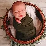 Cheek, Wood, Baby, Toddler, Sleeve, Basket, Baby & Toddler Clothing, Jewellery, Plant, Comfort, Fashion Accessory, Wool, Baby Products, Sitting, Pattern, Circle, Grass, Child, Wicker, Thread, Person