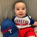 Chin, Smile, Facial Expression, Jersey, Neck, Sleeve, Sports Gear, Baby & Toddler Clothing, Happy, Gesture, Sportswear, Finger, Cool, Headgear, Elbow, Cap, Player, Baseball Cap, Toddler, Knee, Person