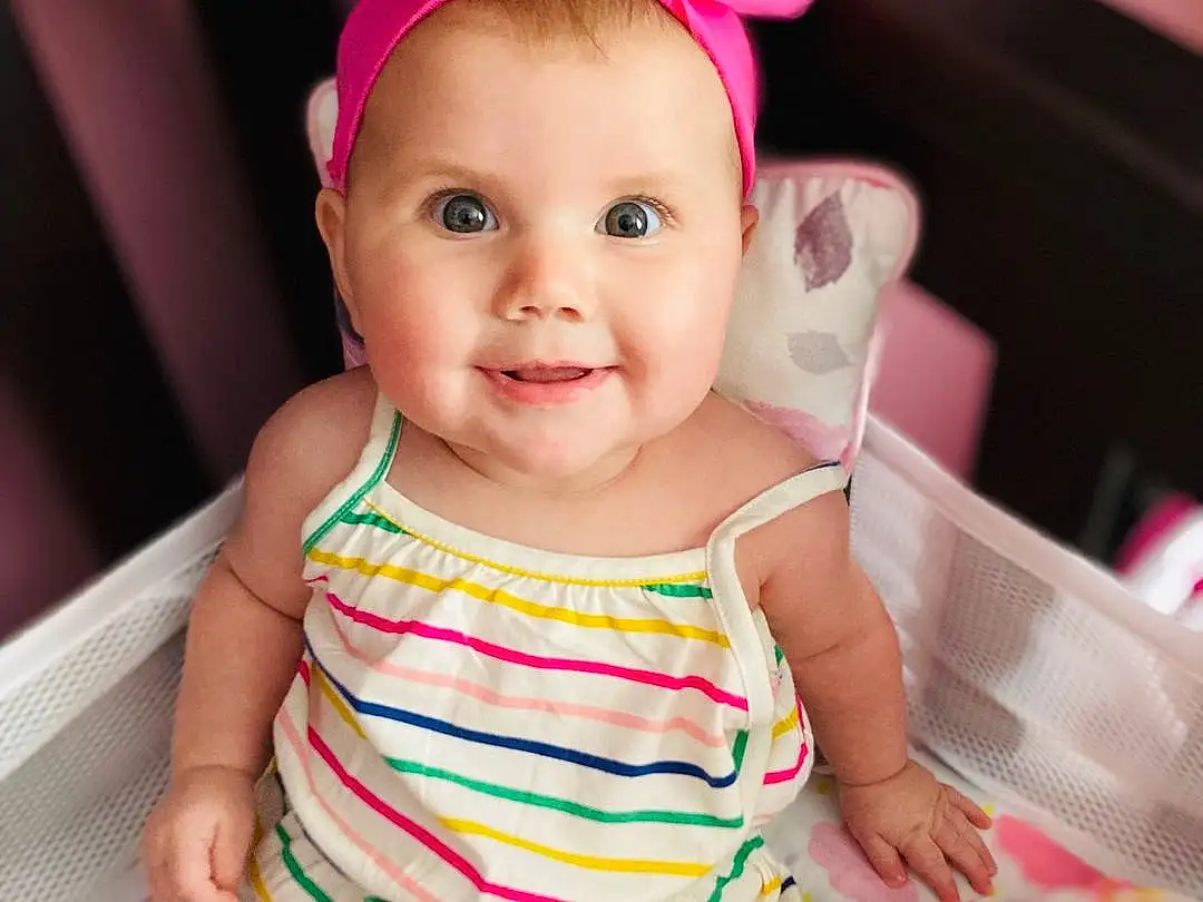 Face, Cheek, Skin, Head, Chin, Smile, Hairstyle, Arm, Eyes, Facial Expression, White, Dress, Baby & Toddler Clothing, Neck, Happy, Sleeve, Pink, Iris, Finger, Toddler, Person, Joy