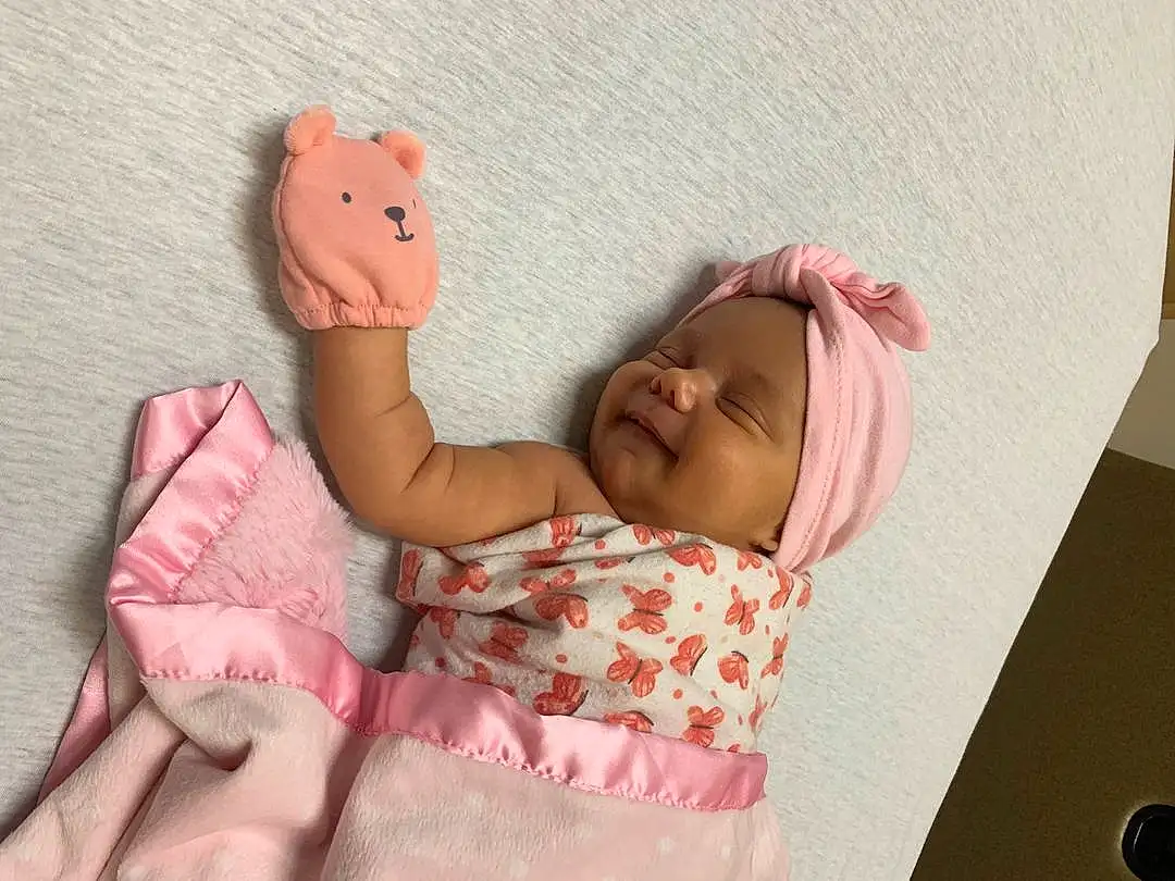 Skin, Hand, Arm, Comfort, Textile, Baby & Toddler Clothing, Gesture, Pink, Baby, Finger, Happy, Baby Sleeping, Bed, Toddler, Child, Linens, Toy, Bedding, Baby Products, Bedtime, Person, Headwear
