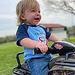 Tire, Wheel, Smile, Photograph, Sky, Vehicle, Automotive Tire, Tread, Riding Toy, Vroom Vroom, Happy, Baby & Toddler Clothing, Grass, Automotive Lighting, Finger, T-shirt, Toddler, Fender, Rolling, Tree, Person