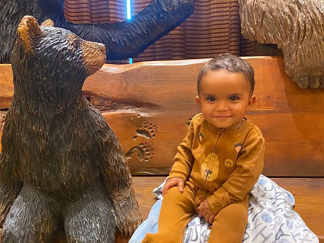 Smile, Human Body, Temple, Fun, Toddler, Happy, Art, Brown Bear, Wood, Event, Furry friends, Child, Grizzly Bear, Leisure, Tradition, Lawn Ornament, Bear, Person, Joy