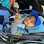 Vroom Vroom, Smile, Blue, Baby Carriage, Automotive Design, Comfort, Car Seat, Car Seat Cover, Toddler, Fun, Auto Part, Baby Products, Head Restraint, Child, Electric Blue, Lap, Automotive Exterior, Vehicle Door, Steering Wheel, Steering Part, Person, Joy, Headwear