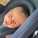 Cheek, Skin, Eyebrow, Eyes, Comfort, Smile, Baby Carriage, Iris, Baby, Car Seat, Material Property, Toddler, Auto Part, Window, Automotive Design, Child, Vehicle Door, Baby Products, Happy, Person, Joy