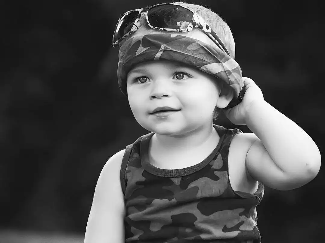 Flash Photography, People In Nature, Baby & Toddler Clothing, Happy, Black-and-white, Style, Grass, Headgear, Toddler, Goggles, Cap, Monochrome, Black & White, Baby, Fun, Child, Grassland, Sitting, Darkness, Stock Photography, Person, Headwear