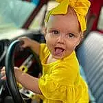Smile, Yellow, Happy, Baby, Toddler, Fun, Steering Wheel, Party Supply, Wheel, Event, Hat, Recreation, Child, Leisure, Vroom Vroom, Baby Products, Costume Hat, Family Car, Auto Part, Fashion Accessory, Person, Surprise