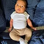 Cheek, Skin, Eyes, Baby & Toddler Clothing, Flash Photography, Comfort, Sleeve, Baby, Toddler, Happy, Child, Human Leg, Knee, Sitting, Thigh, Linens, Fashion Accessory, T-shirt, Couch, Sock, Person