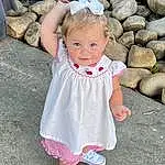 Face, Hair, Skin, Head, Smile, Eyes, White, Dress, Baby & Toddler Clothing, Human Body, Sleeve, Standing, Happy, Gesture, Pink, People In Nature, Baby, Toddler, Fun, Grass, Person, Joy