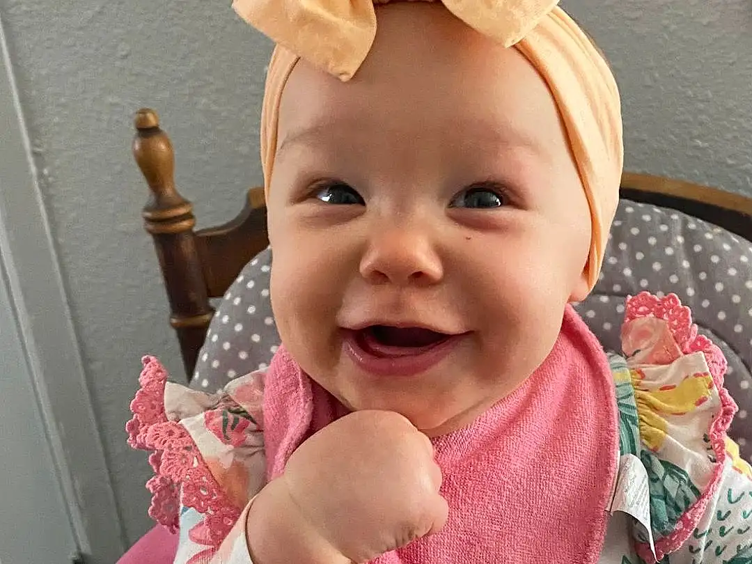 Face, Smile, Cheek, Skin, Head, Eyes, Baby & Toddler Clothing, Baby, Sleeve, Ear, Happy, Gesture, Pink, Finger, Toddler, Thumb, Child, Fun, Baby Products, Fashion Accessory, Person, Joy