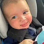 Face, Nose, Cheek, Skin, Head, Smile, Hairstyle, Eyes, Facial Expression, Gesture, Iris, Finger, Toddler, Comfort, Flash Photography, Car Seat, Baby, Seat Belt, Baby In Car Seat, Person, Joy