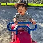 Face, Riding Toy, Vehicle, Hat, Leisure, Tree, Toddler, Plant, Fun, Sun Hat, Recreation, Electric Blue, Grass, Baby & Toddler Clothing, Happy, Cap, Child, Sitting, City, Person