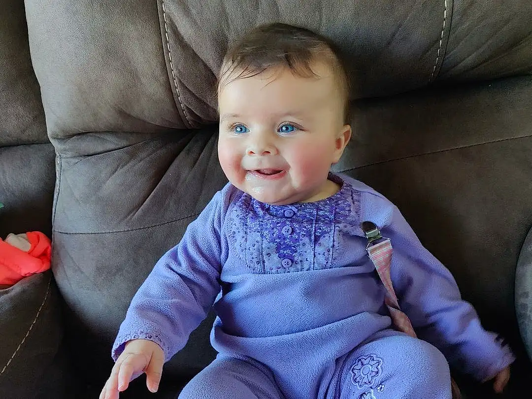 Cheek, Smile, Comfort, Purple, Baby & Toddler Clothing, Sleeve, Couch, Thigh, Toddler, Baby, Sock, Happy, T-shirt, Electric Blue, Knee, Sitting, Human Leg, Lap, Child, Chair, Person, Joy