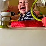 Smile, Happy, Toddler, Baby Laughing, Baby, Leisure, Baby Products, Comfort, Fun, Baby Toys, Play, Child, Room, Baby Playing With Toys, Toy, Baby Safety, Magenta, Pattern, Infant Bed, Nursery, Person