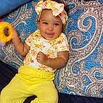 Head, Smile, Facial Expression, Happy, Yellow, Baby & Toddler Clothing, Toddler, Child, Baby, Thigh, Fun, Leisure, Event, Magenta, Pattern, Sitting, T-shirt, Human Leg, Abdomen, Tradition, Person, Joy, Headwear