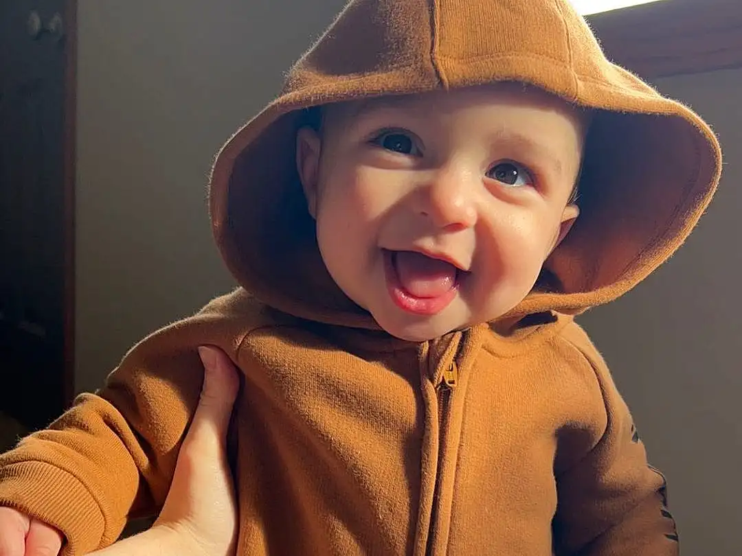 Nose, Face, Cheek, Skin, Head, Lip, Smile, Outerwear, Shoulder, Mouth, Human Body, Neck, Cap, Sleeve, Happy, Toddler, Jacket, Baby & Toddler Clothing, Hat, Person, Headwear