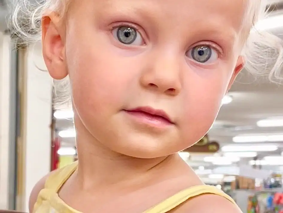Nose, Cheek, Joint, Skin, Lip, Eyelash, Neck, Sleeve, Iris, Baby & Toddler Clothing, Happy, Toddler, Beauty, Chest, Child, Blond, Close-up, Brown Hair, Baby, Day Dress, Person