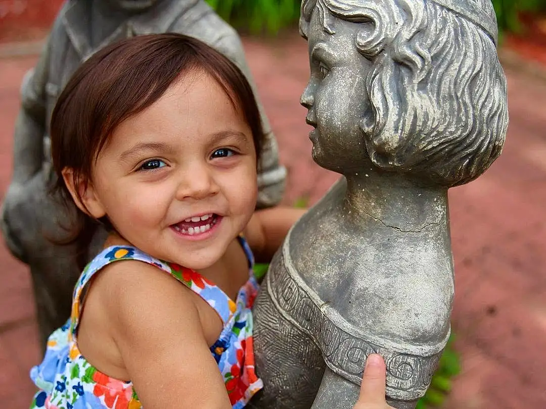 Smile, Skin, Chin, Facial Expression, Temple, Happy, Leisure, Public Space, Sculpture, Summer, People In Nature, Art, Statue, Fun, Toddler, Lawn Ornament, Child, Friendship, Event, Grass, Person, Joy