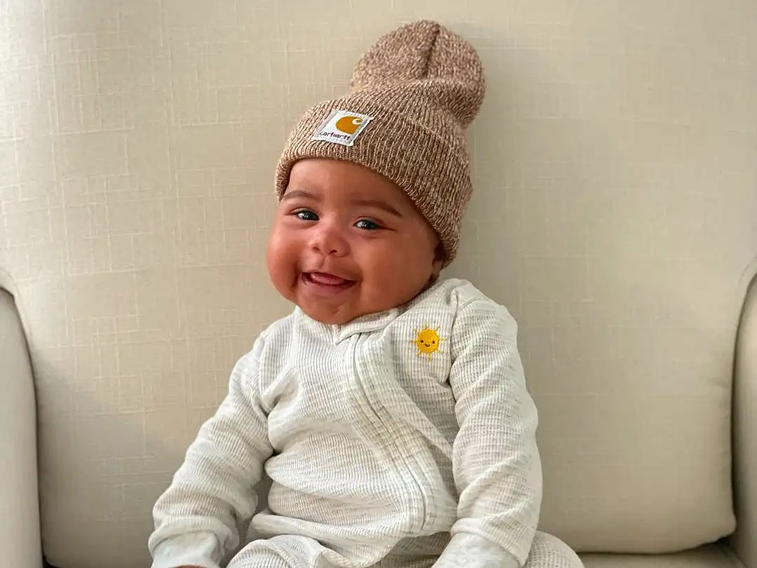 Face, Head, Skin, Outerwear, Smile, Comfort, Baby & Toddler Clothing, Sleeve, Baby, Cap, Toddler, Collar, Knit Cap, Child, Sitting, Fashion Accessory, Costume Hat, Woolen, Beanie, Person, Joy, Headwear