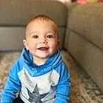 Nose, Cheek, Skin, Smile, Head, Eyes, Facial Expression, Baby & Toddler Clothing, Sleeve, Standing, Iris, Happy, Comfort, Toddler, Baby, Child, Wood, Couch, Person, Joy