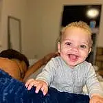 Skin, Smile, Hairstyle, Facial Expression, Couch, Comfort, Sleeve, Gesture, Finger, Happy, Baby & Toddler Clothing, Flash Photography, Toddler, Chair, Fun, Room, Baby, Lap, Sitting, Person, Joy