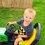 Wheel, Smile, Tire, Toy, Riding Toy, Automotive Tire, Vehicle, Grass, Shorts, Toddler, T-shirt, Leisure, Child, Lawn, Vroom Vroom, Automotive Design, Plant, Recreation, Happy, Fun, Person, Joy
