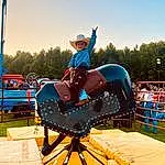 Sky, Tree, Leisure, Recreation, Fun, Electric Blue, Outdoor Play Equipment, Sports, Grass, Sports Equipment, Bridle, Playground, Animal Sports, Horse Tack, Nonbuilding Structure, Saddle, Competition, Amusement Ride, Competition Event, Sport Venue, Person, Joy, Headwear