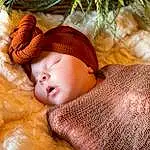 Head, Skin, Comfort, Wood, Plant, Christmas Tree, Fawn, Baby, People In Nature, Grass, Tree, Event, Furry friends, Peach, Linens, Fashion Accessory, Child, Toddler, Conifer, Holiday, Person