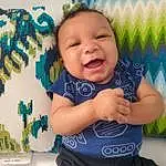 Cheek, Skin, Smile, Eyes, Azure, Baby & Toddler Clothing, Textile, Happy, Sleeve, Baby, Iris, Finger, Toddler, Baby Laughing, T-shirt, Pattern, Child, Electric Blue, People In Nature, Baby Products, Person