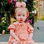 Head, Hairstyle, Plant, Dress, Sleeve, Baby & Toddler Clothing, Happy, Pink, Grass, Toddler, Baby, Day Dress, Embellishment, Child, Pattern, Peach, Sitting, Headpiece, Flower, Hair Accessory, Person