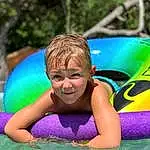 Water, Smile, Facial Expression, Outdoor Recreation, Body Of Water, Happy, Leisure, People In Nature, Aqua, Fun, Toddler, Summer, Recreation, Child, Bathing, Grass, Beauty, Inflatable, Personal Protective Equipment, Swimwear, Person, Joy
