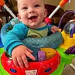 Smile, Baby Playing With Toys, Photograph, Facial Expression, Riding Toy, Baby, Baby & Toddler Clothing, Toddler, Fun, Happy, Toy, Child, Leisure, Grass, Baby Products, Recreation, Outdoor Play Equipment, Play, Person