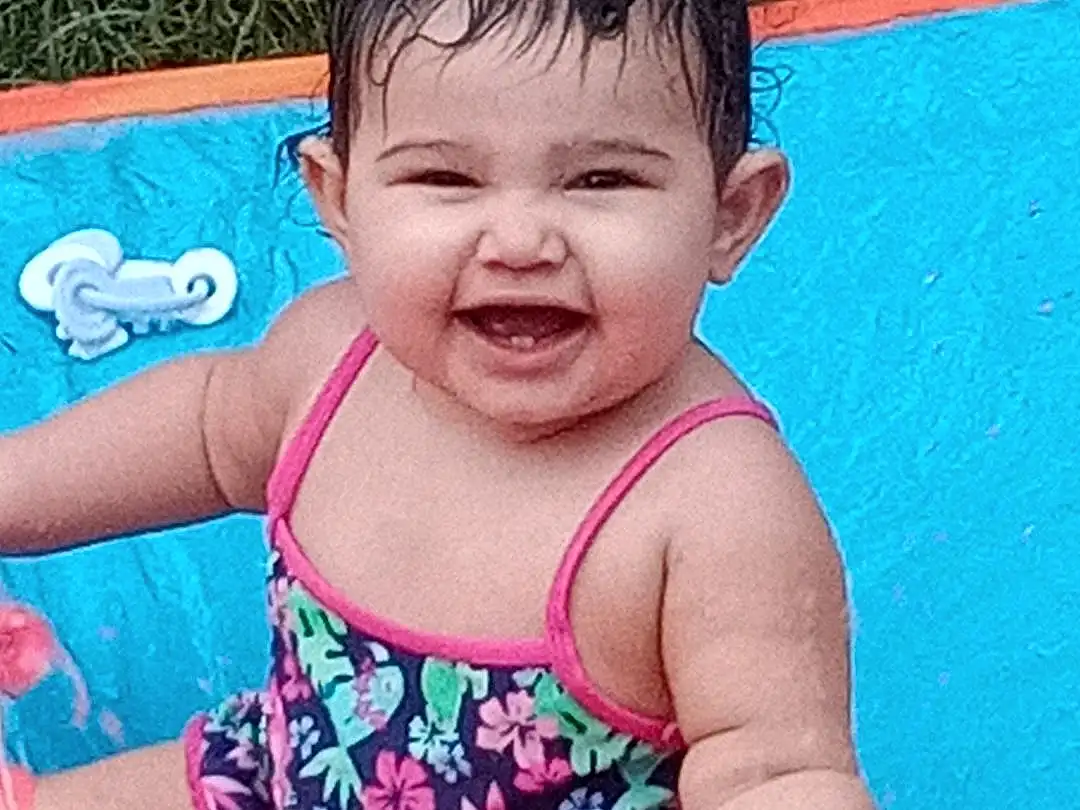 Face, Hair, Cheek, Skin, Head, Water, Smile, Hand, Arm, Eyes, Blue, Human Body, Baby & Toddler Clothing, Happy, Neck, Sleeve, Swimming Pool, One-piece Swimsuit, Thigh, Pink, Person