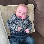 Face, Cheek, Jeans, Head, Skin, Shoe, Arm, Eyes, Leg, Comfort, Baby, Baby & Toddler Clothing, Sleeve, Wood, Toddler, Lap, Couch, Flash Photography, Sitting, Person