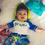 Cheek, Skin, Head, Arm, Eyes, Facial Expression, Azure, Baby & Toddler Clothing, Textile, Happy, Iris, Baby, Toddler, Comfort, Fun, Baby Products, Linens, T-shirt, Sitting, Child, Person