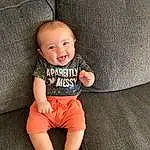 Skin, Smile, Eyes, Flash Photography, Baby & Toddler Clothing, Sleeve, Textile, Standing, Happy, Comfort, Knee, T-shirt, Thigh, Baby, Child, Toddler, Human Leg, Couch, Person