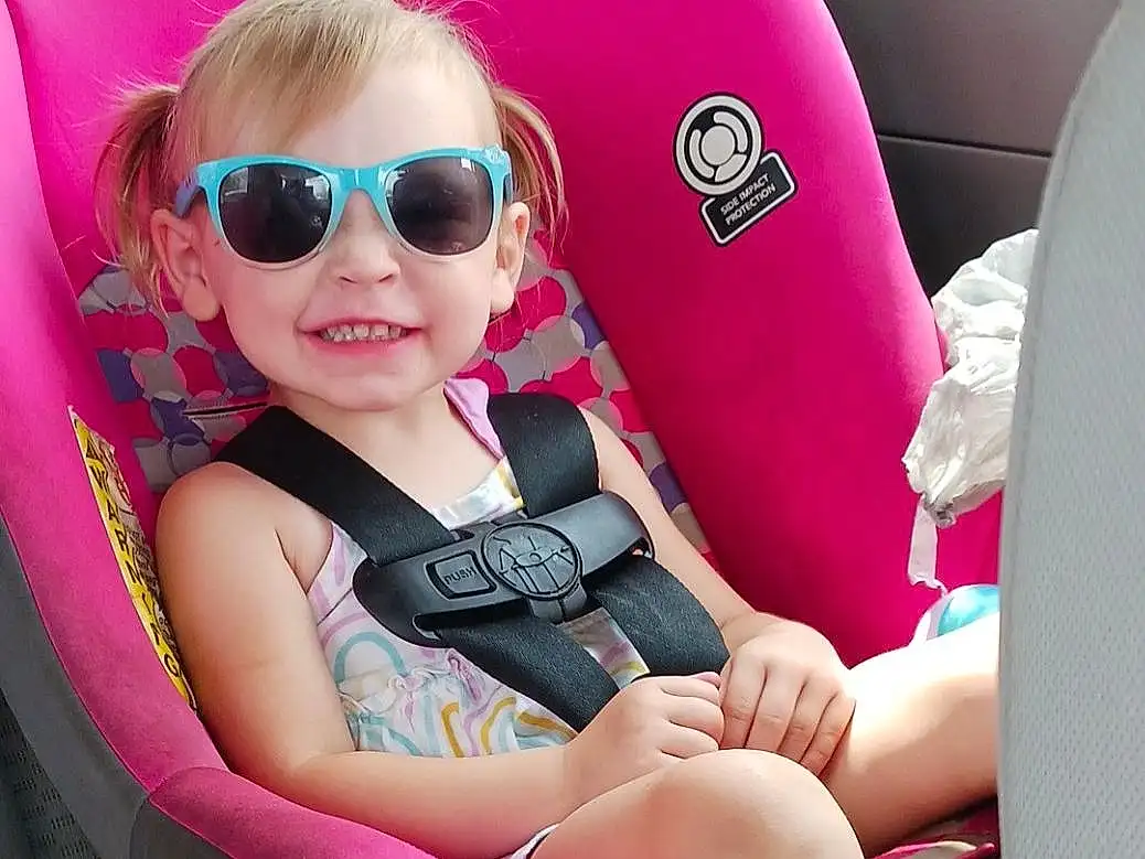 Glasses, Skin, Lip, Shoe, Goggles, Leg, Vision Care, Sunglasses, Comfort, Automotive Design, Vroom Vroom, Eyewear, Dress, Pink, Baby & Toddler Clothing, Vehicle Door, Thigh, Car Seat, Toddler, Car Seat Cover, Person, Joy