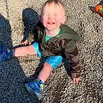Smile, People In Nature, Happy, Grass, Toddler, Baby & Toddler Clothing, Tints And Shades, Road Surface, Electric Blue, Child, Asphalt, Baby, Soil, Human Leg, Thumb, Fun, Sitting, Shadow, T-shirt, Foot, Person